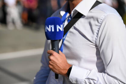 Novinar drži mikrofon dok izvještava uživo u programu. TV reporter. N1 televizija.