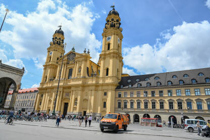 Minhen Minhen, Njemačka. Theatinerkirche je rimokatolička crkva na trgu Odeonsplatz. Crkva u centru grada i ljudi na trgu.