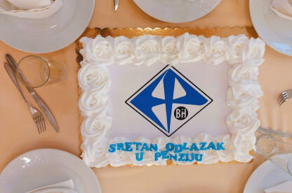 Torta na stolu. Natpis "Sretan odlazak u penziju" sa logotipom Elektroprivrede BiH.