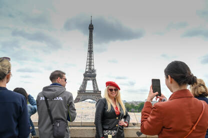 Pariz, Francuska: Turisti fotografišu i prave selfije ispred Ajfelovog tornja. Popularna turistička destinacija.