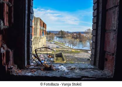 Dom penzionera u Bihaću iznutra. Pogled iz napuštene zgrade u kojoj žive izbjeglice i migranti. Ruševina i smeće oko nje.