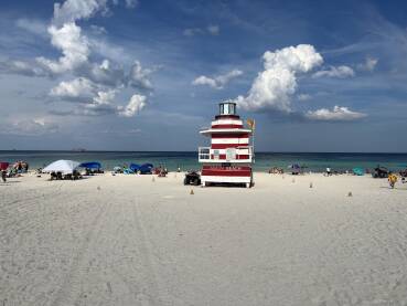 Pogled na pješčanu plažu i spasilačku kućicu s natpisom "Miami Beach"