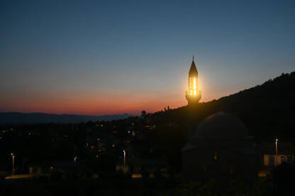 AK1_3770 Silueta minareta i džamije na zalasku sunca. Simbol Islama. Svjetla na munari u svetom mjesecu Ramazanu.