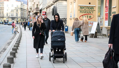 Mlade majke sa dječjim kolicima. Mlade majke sa dječjim kolicima. Mame i bebe. Žena gura dječja kolica u gradu. Roditelji šetaju ulicom. Roditeljstvo.