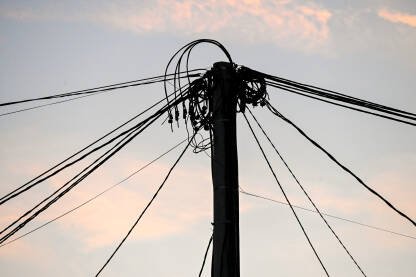Mnogo električnih kablova na banderi. Električna energija. Mnogo električnih kablova na stubu tokom zalaska sunca. Struja. Prijenos električne energije. Električna energija.