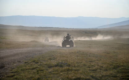 Mnogo kvadova diže prašinu na planini. Turisti voze kvadove. Quad.