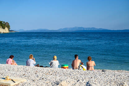 Grupa turista na plaži uz more. Makarska, Hrvatska: Grupa turista na plaži tokom toplog ljetnog dana. Turisti na moru. Ljetni odmor.