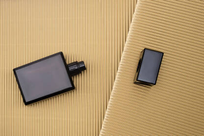 Crna bočica parfema na zlatnoj pozadini - koncept