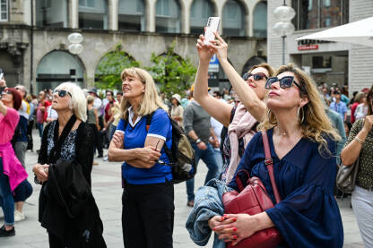 Turisti fotografiraju znamenitosti Turisti fotografiraju znamenitosti u centru grada. Ljudi snimaju mobilnim telefonima.