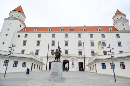 Bratislava, Slovačka. Dvorac iznad starog grada. Turisti. Bratislava, Slovačka. Dvorac na brdu iznad starog grada. Turisti fotografišu dvorac. Popularna turistička destinacija. Spomenik.