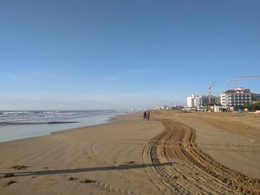 Predivna pjescana plaza idealna za duge jesenje setnje. U daljini radovi na visini.