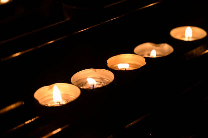 Svijeće gore u crkvi. Zapaljene svijeće u crkvi. Upaljene molitvene svijeće unutar katoličke katedrale.