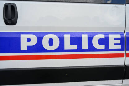 Policijski automobil na ulici. Bočni pogled na policijski automobil sa natpisom "Policija". Policijsko patrolno vozilo parkirano na ulici.