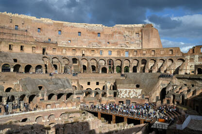 Rim, Italija. Koloseum u centru grada. Turisti u posjeti. Ljudi istražuju jednu od najpoznatijih znamenitosti na svijetu. Rimska arhitektura. Ljudi u Koloseumu.