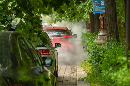 Para oko automobila na parkingu. Kvar na automobilu. Požar na automobilu. Dim oko parkiranih vozila.