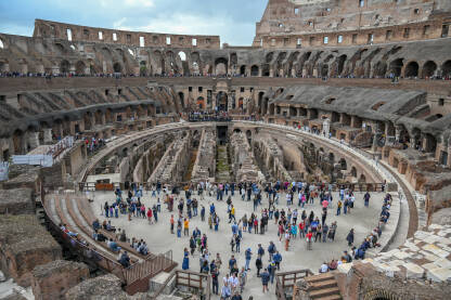 Rim, Italija. Koloseum u centru grada. Turisti u posjeti. Ljudi istražuju jednu od najpoznatijih znamenitosti na svijetu. Rimska arhitektura. Ljudi u Koloseumu.
