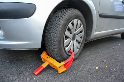 Parkiran auto sa blokadom na točku Parkiran auto sa blokadom na točku. Blokada točkova zbog nepropisnog parkiranja na ulici.