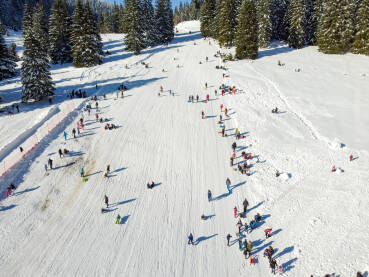 Skijanje na planini Bjelašnica, Bosna i Hercegovina: Mnoštvo ljudi se zabavlja na planini. Grupa turista na planini. Skijanje i sanjkanje zimi. Zimski praznici. Odmor i rekreacija.