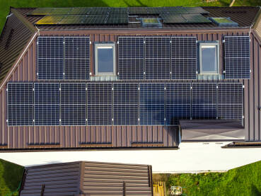 Solarne ploče na vrhu zgrade Solarne ploče na vrhu zgrade, snimak dronom. Proizvodnja električne energije. Solarni paneli na kući. Proizvodnja čiste obnovljive energije od sunca. Fotonaponske solarne ćelije.