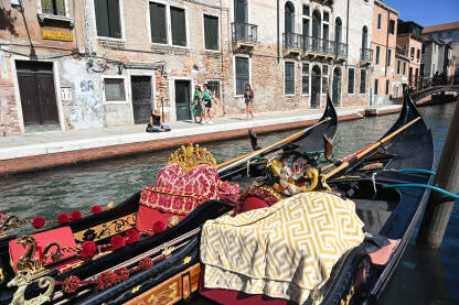Venecija, Italija. Gondole Venecija, Italija. Gondole u kanalu u gradu. Turisti istražuju grad.