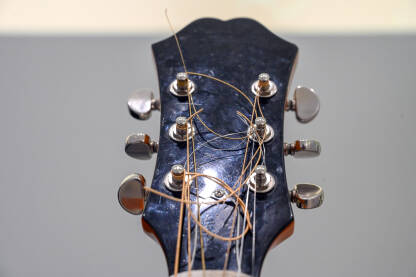 Glava gitare sa klinovima za štimanje i žicama. Krupni plan električne gitare.