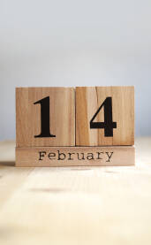 14. Februar, Dan zaljubljenih, Valentinovo Deveni kalendar na stolu sa kockicama okrenutim na datum 14. Februar Velentinovo.