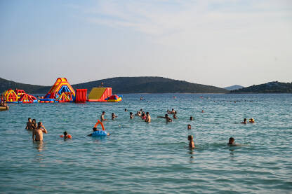 Ljudi u moru Ljudi u moru tokom turističke sezone. Prepuna plaža i more. Godišnji odmor. Turisti na odmoru na Jadranu.