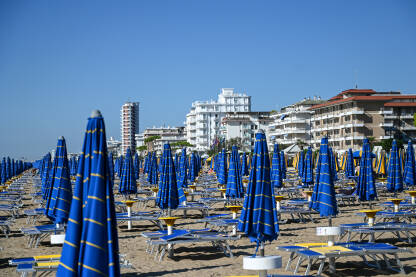 Ležaljke i suncobrani Ležaljke i suncobrani na pješčanoj plaži uz more. Egzotična plaža ljeti. Lido di Jesolo, Italija.