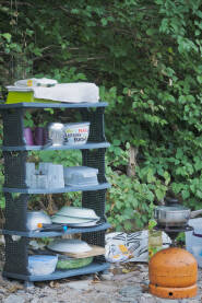 Pribor za kampovanje.
Polica sa posuđem u prirodi