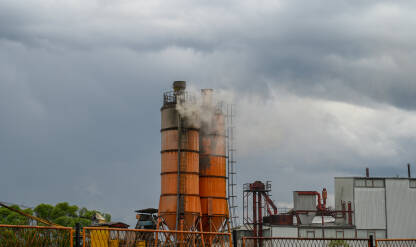 Industrijska zona. Dim iz silosa u fabrici. Industrijska proizvodnja.