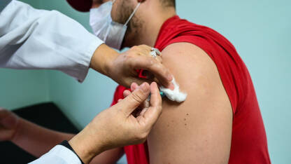 Vakcina. Covid-19. Koronavirus. Čovjek prima vakcinu u rame. Covid vakcinacija. Doktor ubrizgava pacijentu antivirusnu vakcinu Covid-19. Vakcinacija protiv korona virusa.