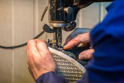 Obućar ušiva cipelu pomoću šivaće mašine