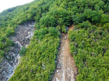 Klizište na obronku u prirodi. Snimak dronom na klizište na planini. Erozija tla na brdu.