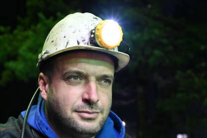 Portret rudara sa kacigom Portret rudara u rudniku. Rudar s kacigom i svjetiljkom na poslu.