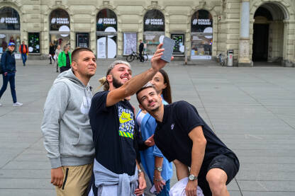 Mladi ljudi prave selfie u gradu. Fotografisanje Mladi ljudi prave selfie u gradu. Fotografisanje sa mobilnim telefonom. Mladići i djevojke na trgu.