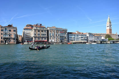 Venecija, Italija: Historijske građevine uz more. Venecija, Italija: Historijske građevine uz more. Popularna turistička destinacija. Gondola na vodi. Turisti istražuju grad.