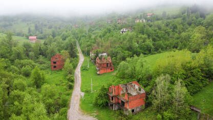 Srušene i oštećene kuće u selu kao posljedica rata. Kuće uništene i spaljene artiljerijom tokom rata, snimak dronom. Kuće u ruševinama. Magla u uništenom selu.