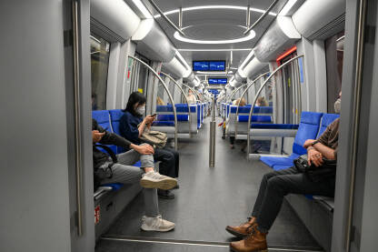 Putnici u vozu podzemne željeznice. Minhen, Njemačka: Putnici sa maskama na licu putuju vozom. U-bahn u Njemačkoj. Prijevoz. Voz podzemne željeznice. Metro. Pandemija koronavirusa.