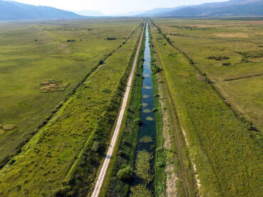 Kanal u Livanjskom polju, snimak dronom. Kanal u Livanjskom polju, snimak dronom. Voda u kanalu. Sistem navodnjavanja i odvođenja viška vode iz polja.