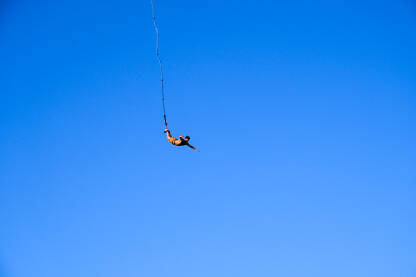 Bungee jumping. Mladić skače bungee jumping. Skok s  užetom. Čovjek se zabavlja Ekstremni sport.