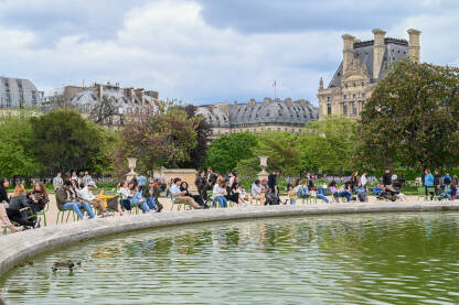 Grupa ljudi uživa u vrtu Tuileries u Parizu Pariz, Francuska: Fontana Grand Bassin Rond. Grupa ljudi šeta vrtom Tuileries. Turisti istražuju grad.
