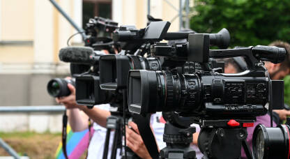 Novinari na terenu Kamere na konferenciji za novinare. Snimanje press događaja video kamerom. Novinarstvo. Profesionalni snimatelji snimaju govore.