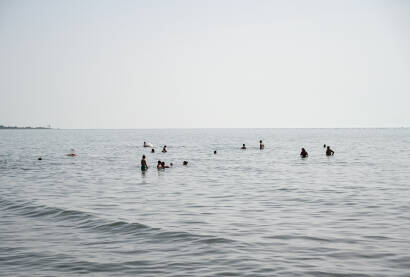 Shëngjin, Albanija, Popularna turistička destinacija. Shëngjin, Albanija. Ljudi plivaju u moru i sunčaju se na plaži. Turisti na ljetnom godišnjem odmori. Popularna turistička destinacija na Jadranskom moru u Albaniji.