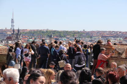 Turisti fotografišu Prag "Zlatna"prijestonica Češke, Prag jedna je od omiljenih destinacija za turiste. Posebna atrakcija je Praški zamak koji, osim što je znamenitost sama za sebe, nudi pogled na cijeli grad.