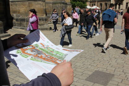 Turista drži mapu Praga Turista sa mapom u ruci šeta Pragom i istražuje kompleks Praški zamak