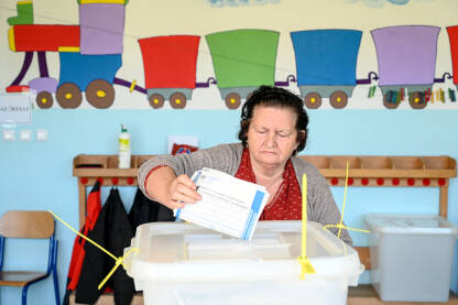 Žena glasa na izborima Žena glasa na izborima. Glasački listići. Izbori u BiH.