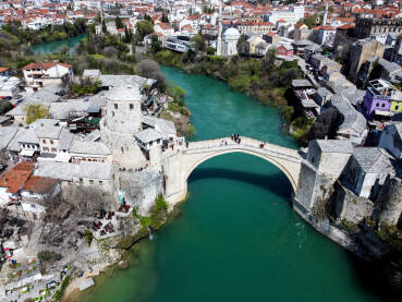 Stari most Stari most i rijeka Neretva u Mostaru, Bosna i Hercegovina. Panoramski snimak dronom, grad Mostar u proljeće.