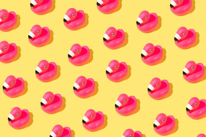Ružičaste flamingo gumene ptice na žutoj pozadini.