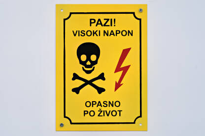 Znak pazi visoki napon, opasno po život (2) Znak za opasnost od strujnog udara. Znak upozorenja na trafostanici. Natpis: Pazi! Visoki napon. Opasno po život.