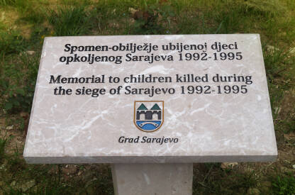Spomenik ubijenoj djeci opkoljenog Sarajeva Tabla spomenika ubijenoj djeci grada Sarajeva u velikom parku.